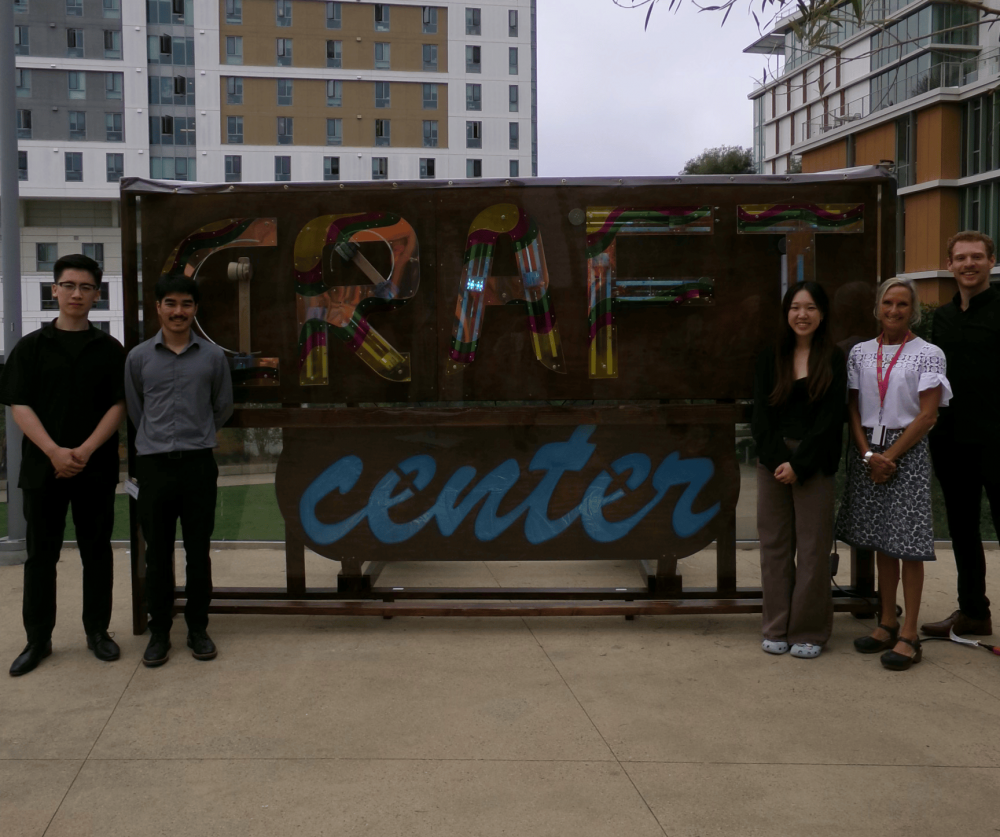 Craft Center sign team members and sponsor in front of the sign they built.