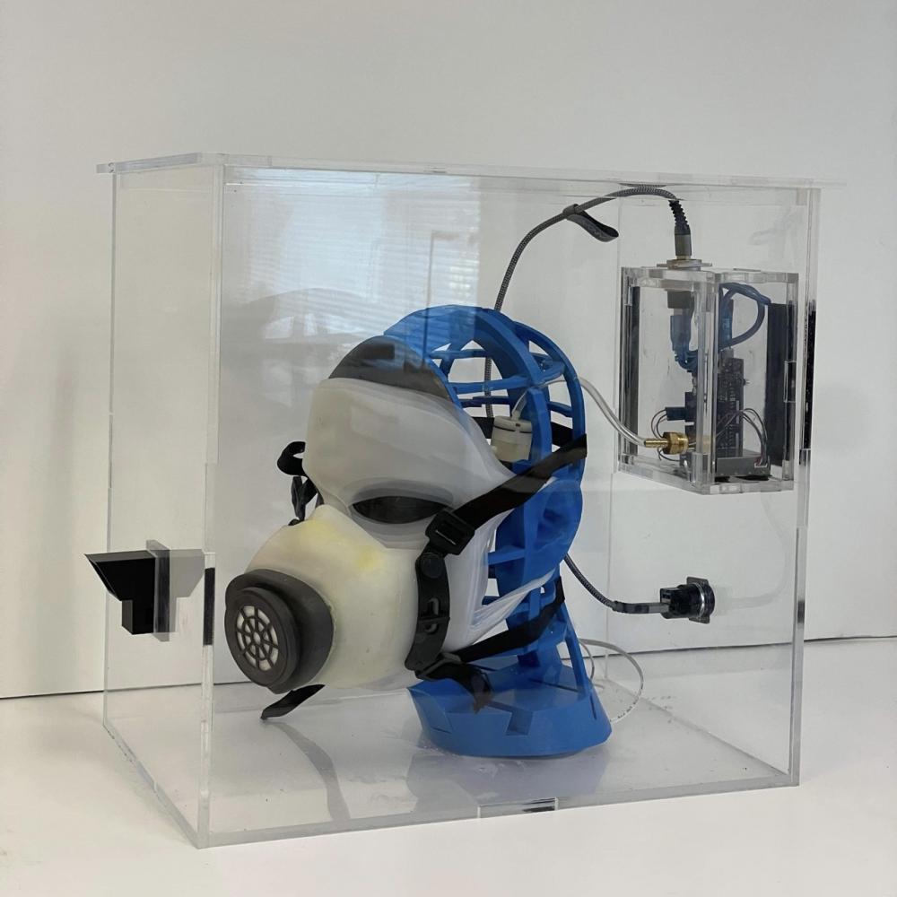 The image shows the designed respirator, the testbed, and the head model