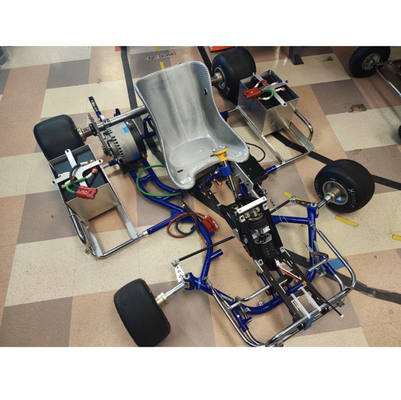 Photo shows the autonomous car, consisting of a center seat and a frame with semi-exposed components.