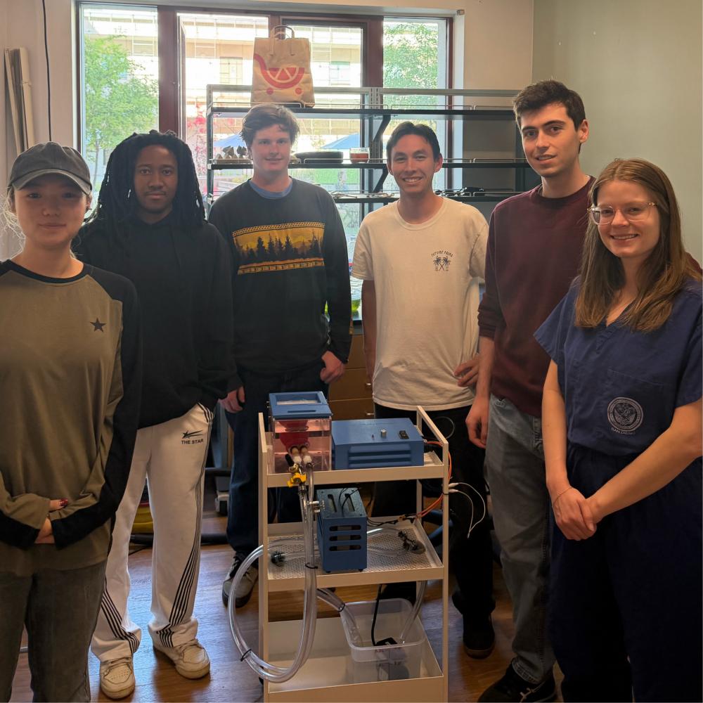 Photo of team and sponsor standing around prototype pericardiocentesis trainer model.