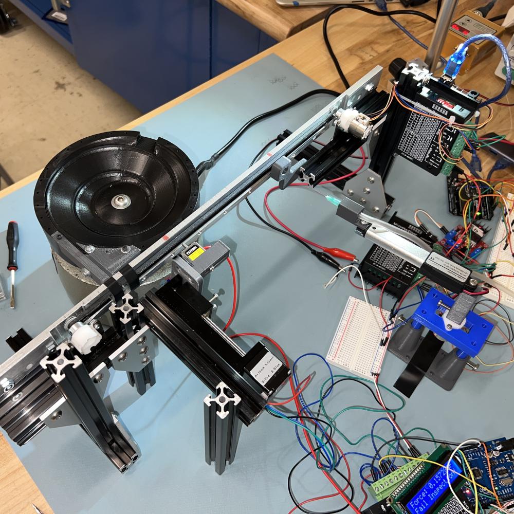 The assembled automating system consists of a vibratory bowl feeder subsystem, a conveyor belt subsystem, a force test module, and a visual inspection module.